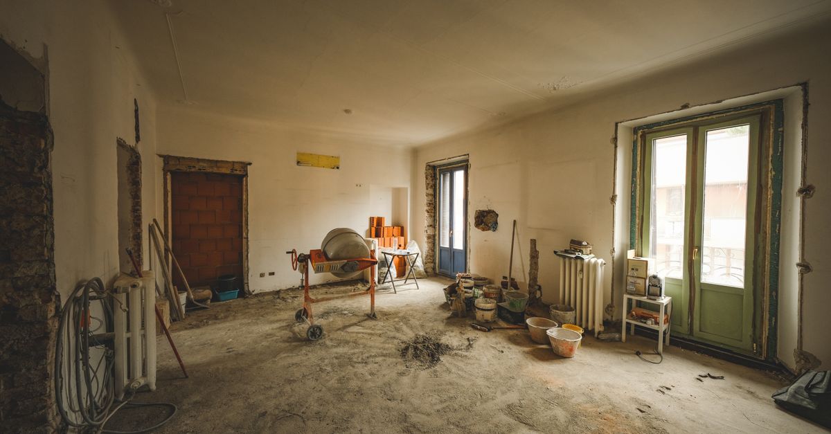 Wide view of a sunny room under renovation with construction materials and tools present, ideal for home improvement concepts.